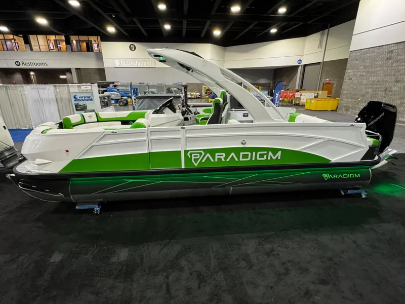 Slide: The Image of 2025 Paradigm 25SS pontoon boat with green accents displayed indoors. - 8