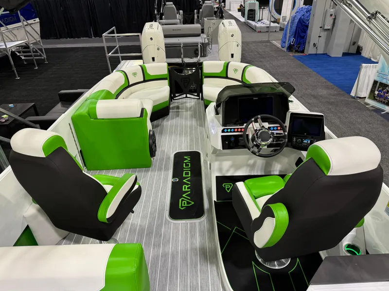 Slide: The Image of 2025 Paradigm 25SS boat interior with green and white seating, modern dashboard, and steering wheel. - 9