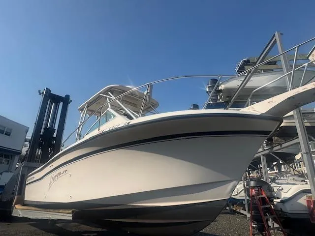Slide: The Image of 1994 Grady-White Explorer 244 boat on dry dock under clear blue sky. - 10