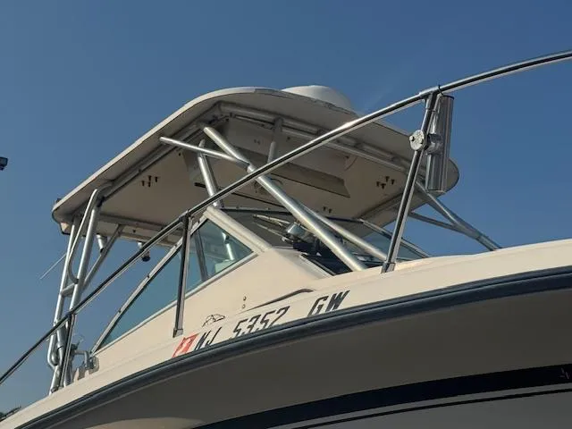 Slide: The Image of 1994 Grady-White Explorer 244 boat with metal framework and clear blue sky background. - 11