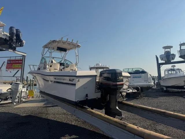 Slide: The Image of 1994 Grady-White Explorer 244 boat on a trailer, with Yamaha outboard motor, in a marina. - 4