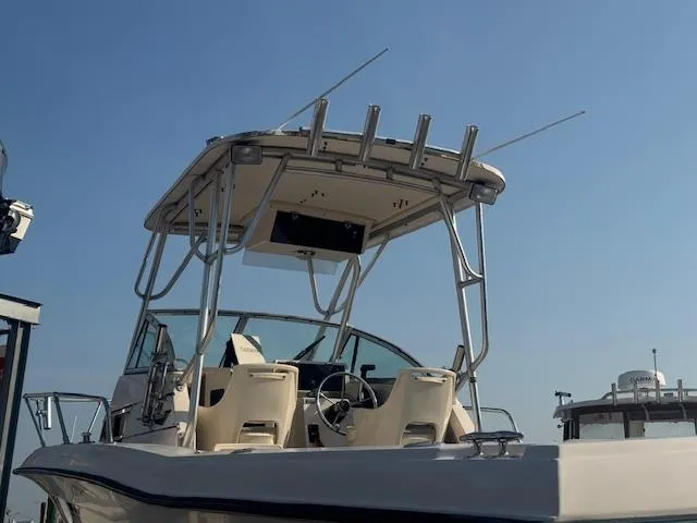 Slide: The Image of 1994 Grady-White Explorer 244 boat with T-top and fishing rod holders under clear sky. - 6