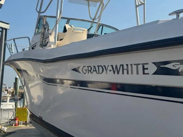 Slide: The Image of 1994 Grady-White Explorer 244 boat docked, showcasing sleek design and branding. - 7