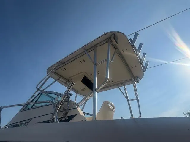 Slide: The Image of 1994 Grady-White Explorer 244 boat with T-top under clear blue sky. - 8