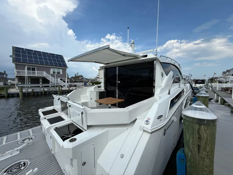 Slide: The Image of 2018 Cruisers Yachts 42 Cantius docked, featuring sleek design and spacious deck area. - 16