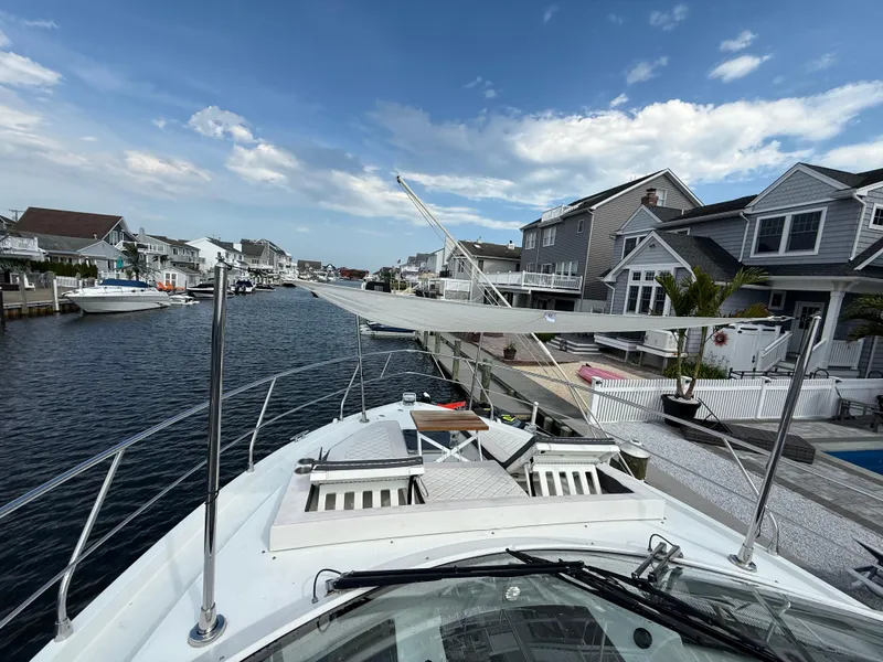 Slide: The Image of 2018 Cruisers Yachts 42 Cantius docked in a scenic residential canal. - 21