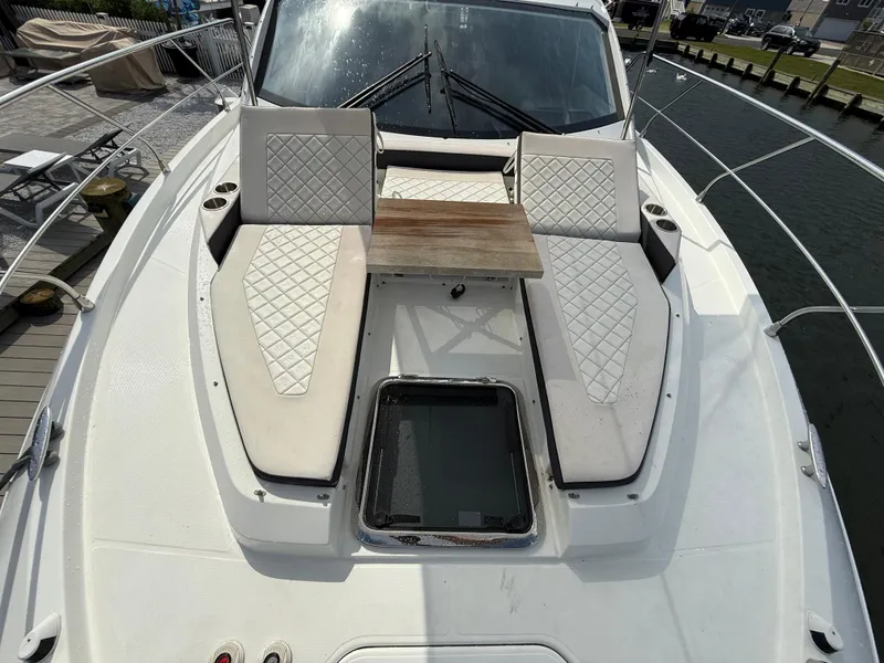 Slide: The Image of 2018 Cruisers Yachts 42 Cantius bow with cushioned seating and wooden table. - 24