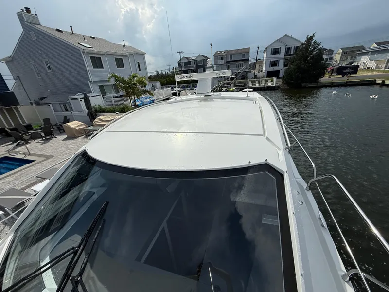 Slide: The Image of 2018 Cruisers Yachts 42 Cantius docked near waterfront homes, showcasing sleek design. - 25