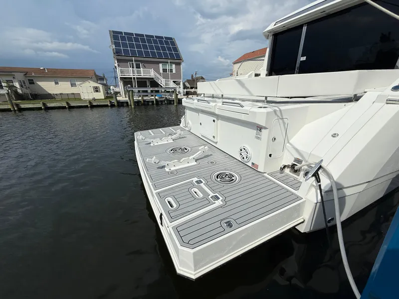Slide: The Image of 2018 Cruisers Yachts 42 Cantius docked, featuring spacious swim platform and modern design. - 8