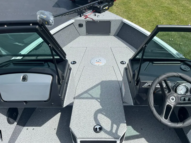 Slide: The Image of 2026 Lund 1675 Adventure Sport boat interior with steering wheel and open windshield. - 12