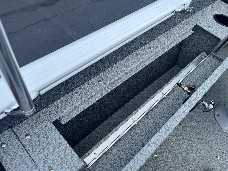 Slide: The Image of 2026 Lund 1675 Adventure Sport boat storage compartment with textured interior and metal latch. - 20