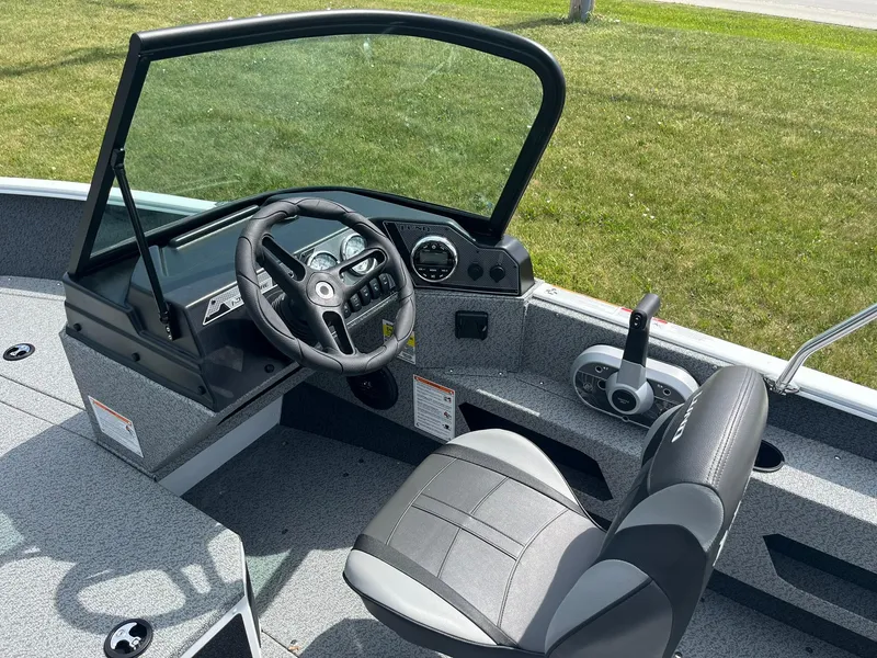 Slide: The Image of 2026 Lund 1675 Adventure Sport boat interior with steering wheel and seat. - 9