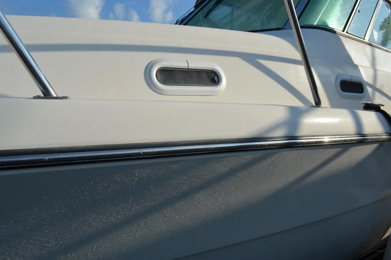 Slide: The Image of 2003 Pursuit 3000 Express boat side view with window and railing details. - 14