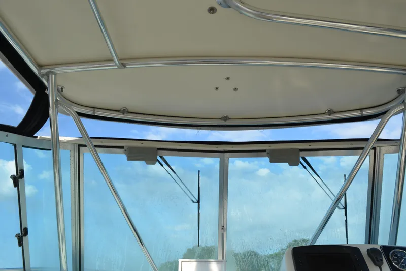 Slide: The Image of Interior view of 2003 Pursuit 3000 Express boat cockpit with clear windows and metal framework. - 19