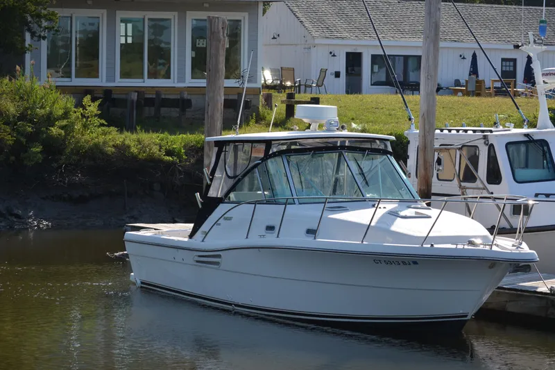 Slide: The Image of 2003 Pursuit 3000 Express boat docked near waterfront buildings. - 2