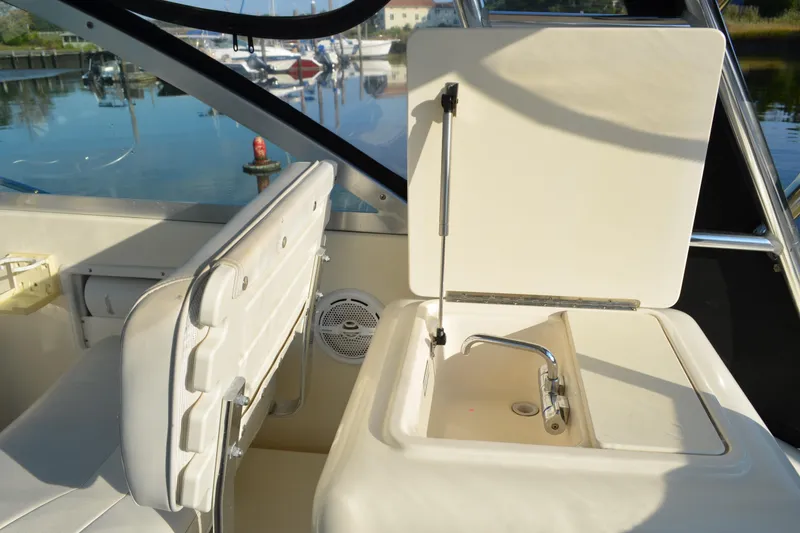 Slide: The Image of 2003 Pursuit 3000 Express boat interior with sink and seating area. - 27