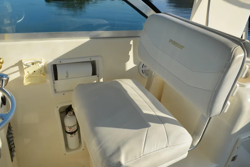 Slide: The Image of 2003 Pursuit 3000 Express boat interior with white seating and safety equipment. - 28