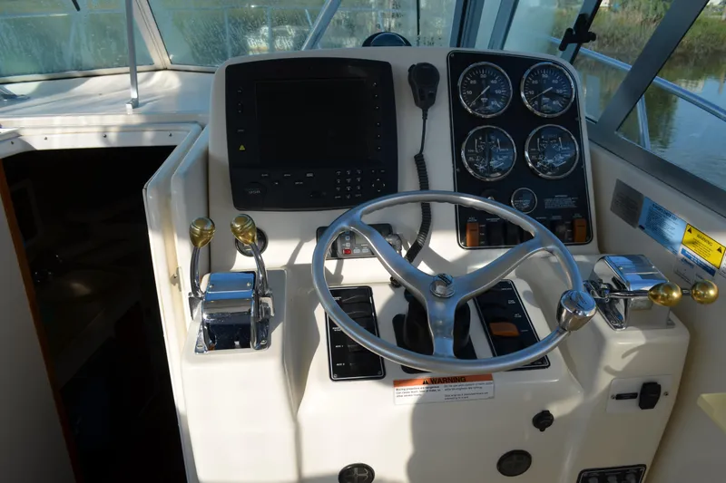 Slide: The Image of Cockpit of 2003 Pursuit 3000 Express boat with steering wheel and control panel. - 29