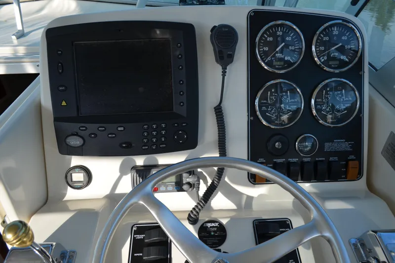 Slide: The Image of 2003 Pursuit 3000 Express boat dashboard with gauges, steering wheel, and control panel. - 30