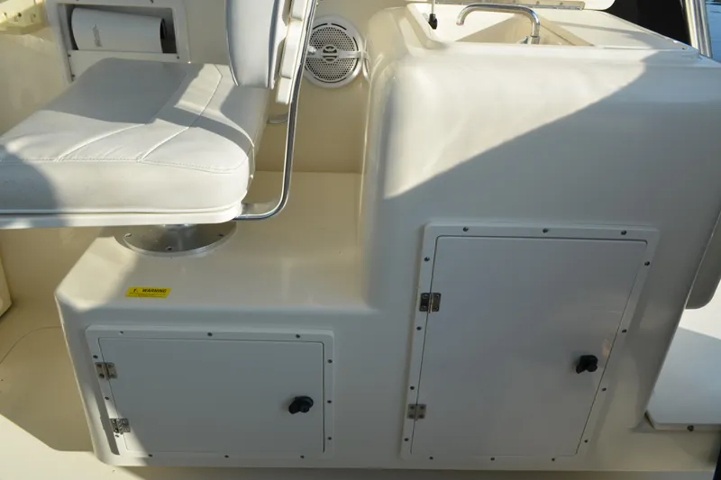 Slide: The Image of 2003 Pursuit 3000 Express boat interior with seat, storage, and sink. - 32