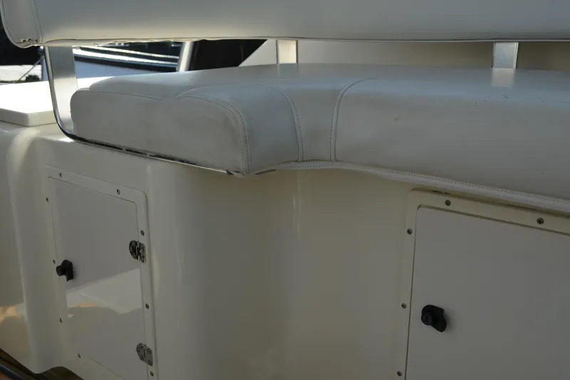 Slide: The Image of 2003 Pursuit 3000 Express boat interior with white seating and storage compartments. - 34