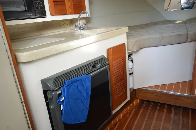 Slide: The Image of 2003 Pursuit 3000 Express cabin interior with kitchenette and bed. - 39