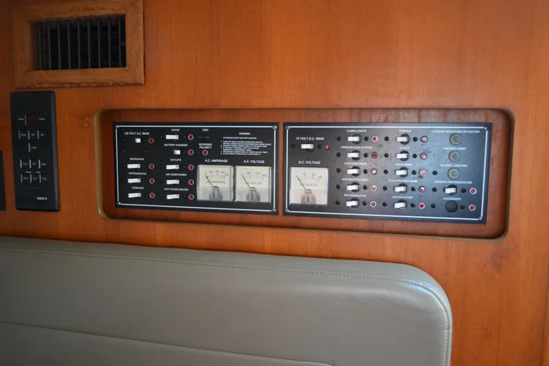 Slide: The Image of Electrical control panel on a 2003 Pursuit 3000 Express boat, featuring various switches and gauges. - 44