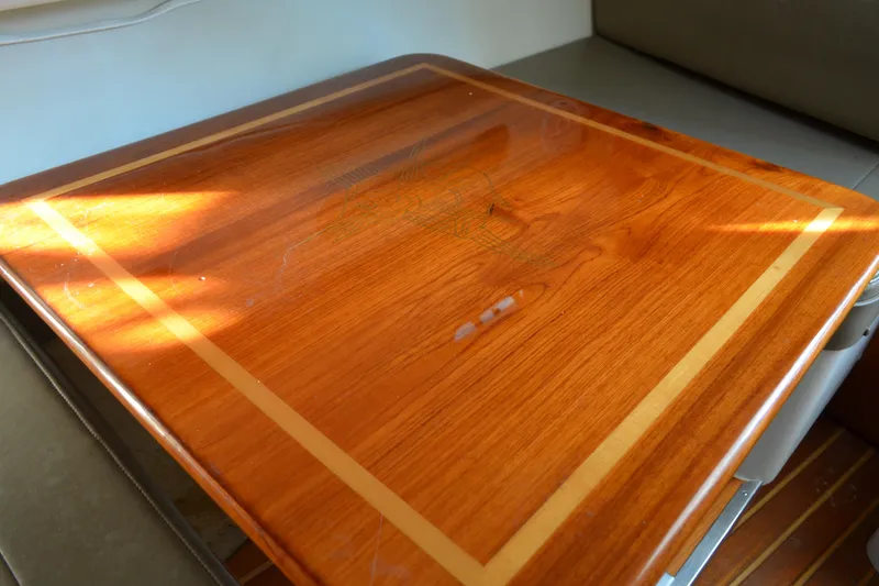 Slide: The Image of Wooden table surface inside a 2003 Pursuit 3000 Express boat, with sunlight highlighting the grain. - 45