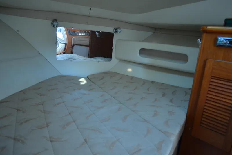 Slide: The Image of 2003 Pursuit 3000 Express cabin interior with bed and wooden cabinetry. - 46