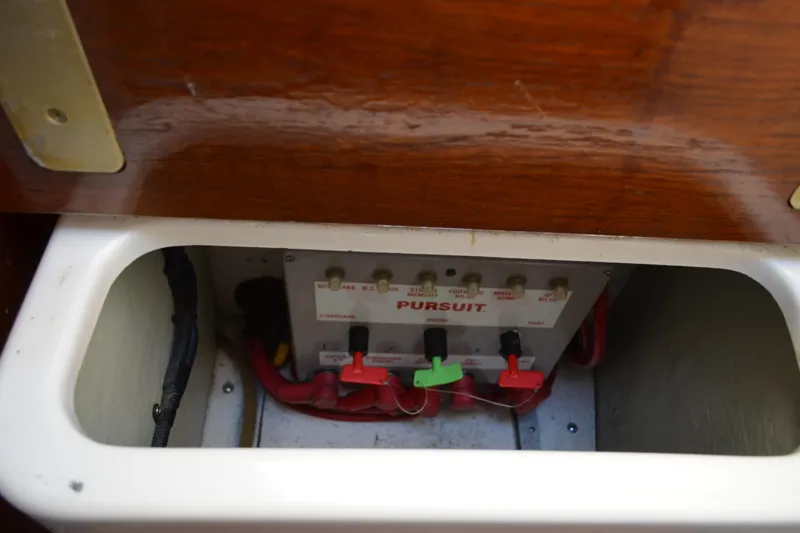 Slide: The Image of Control panel of a 2003 Pursuit 3000 Express boat, featuring switches and wiring. - 54