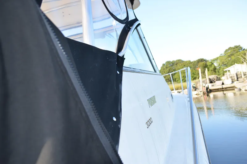 Slide: The Image of 2003 Pursuit 3000 Express boat docked by calm waters, side view. - 55