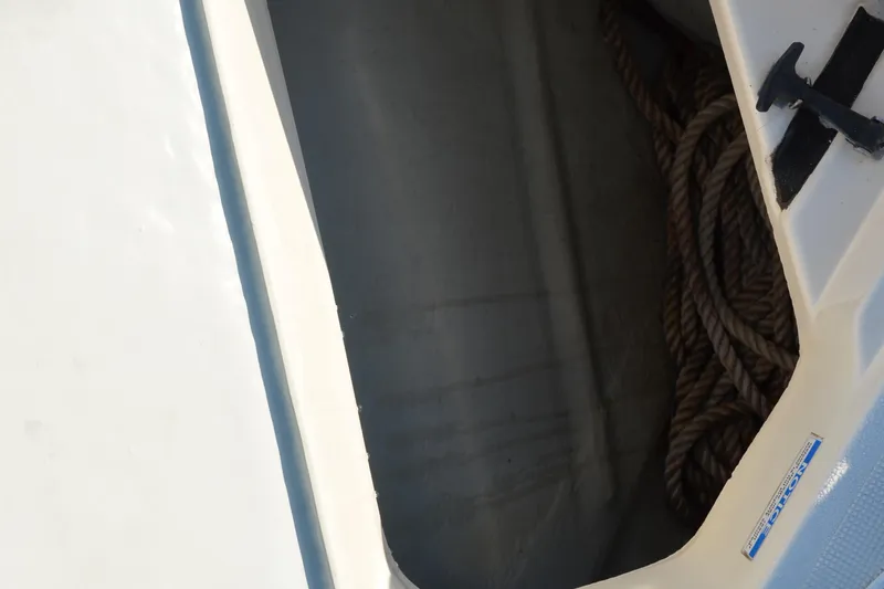 Slide: The Image of Storage compartment with rope on a 2003 Pursuit 3000 Express boat. - 56