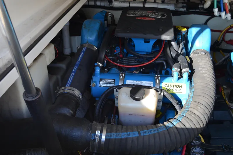 Slide: The Image of Engine compartment of a 2003 Pursuit 3000 Express boat, featuring various components and hoses. - 57