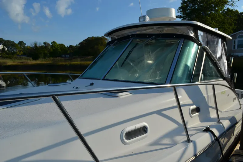 Slide: The Image of 2003 Pursuit 3000 Express boat docked, showcasing sleek design and windshield details. - 6