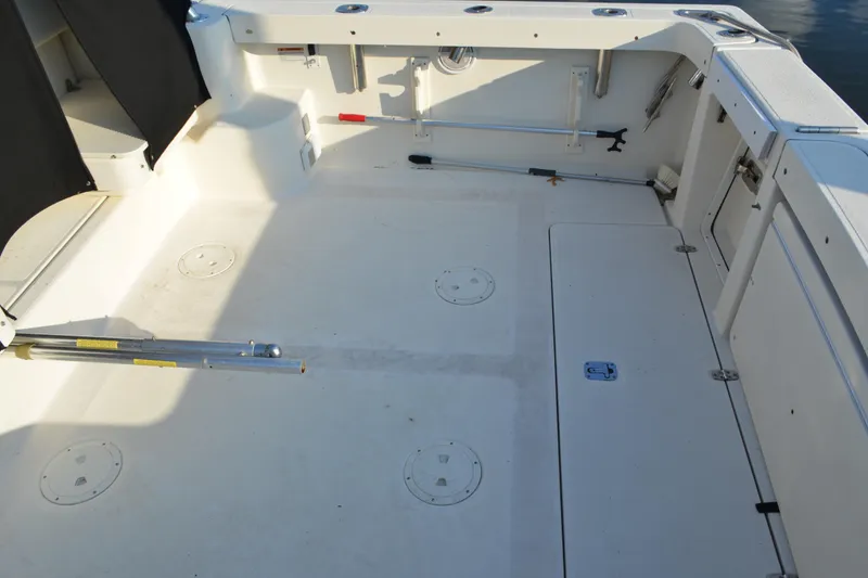 Slide: The Image of 2003 Pursuit 3000 Express boat deck with storage compartments and fishing rod holders. - 17