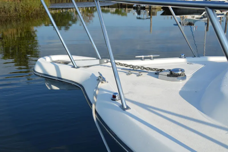 Slide: The Image of Bow of 2003 Pursuit 3000 Express boat with anchor chain, docked on calm water. - 8