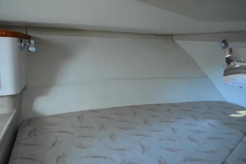 Slide: The Image of Interior cabin of a 2003 Pursuit 3000 Express boat with patterned bedding. - 48