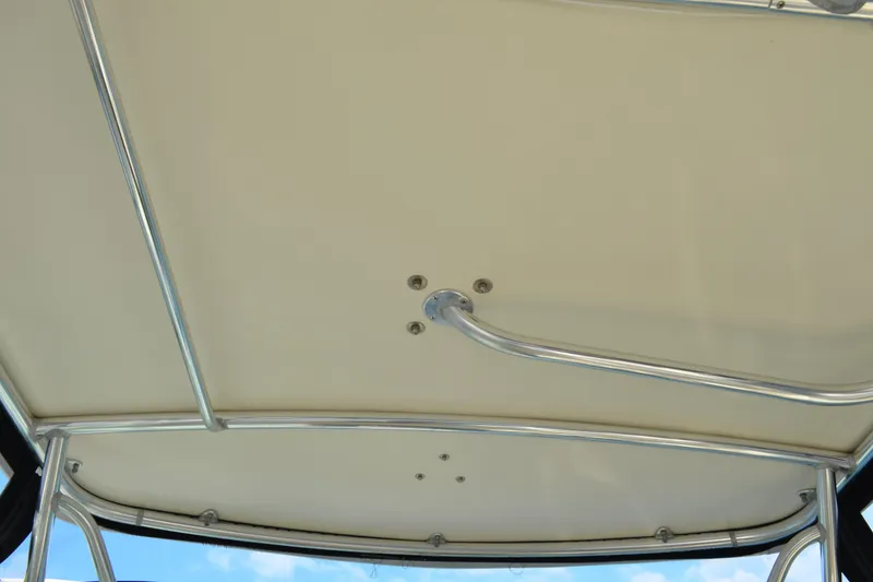 Slide: The Image of 2003 Pursuit 3000 Express boat canopy with metal frame against blue sky. - 18