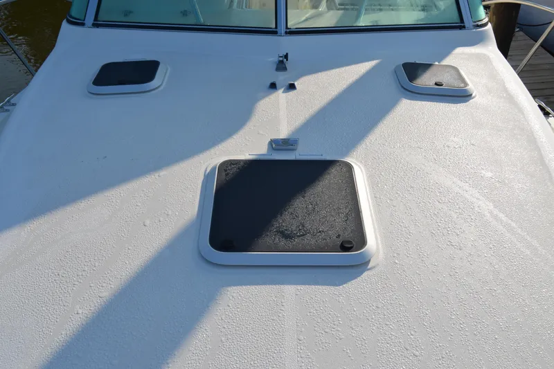 Slide: The Image of 2003 Pursuit 3000 Express boat deck with hatches and textured surface. - 12
