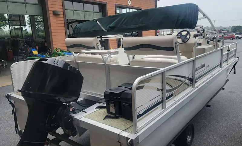 Slide: The Image of 1999 Landau 18 FISH pontoon boat with canopy and outboard motor in a parking area. - 7