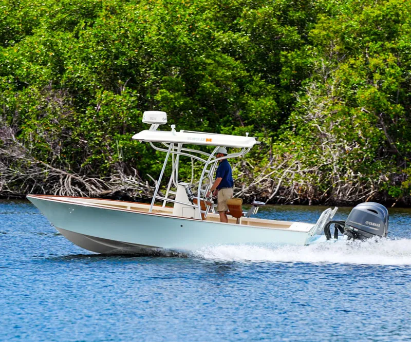 Slide: The Image of 1969 SeaCraft Potter hull boat cruising on water near lush greenery. - 10