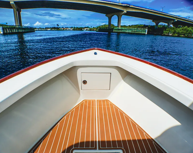 Slide: The Image of 1969 SeaCraft Potter hull boat on water, under a bridge, with clear skies. - 11