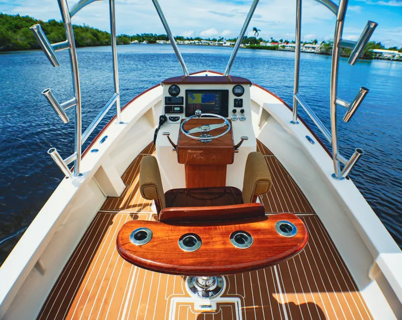 Slide: The Image of 1969 SeaCraft Potter hull boat interior with steering wheel, wooden deck, and scenic water view. - 5