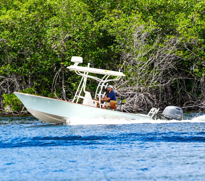 Slide: The Image of 1969 SeaCraft Potter hull boat cruising on water near lush green shoreline. - 7