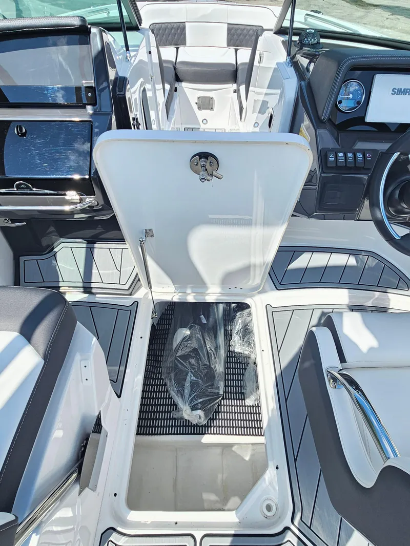 Slide: The Image of 2025 Monterey M-45 boat interior with open storage compartment and modern dashboard. - 27