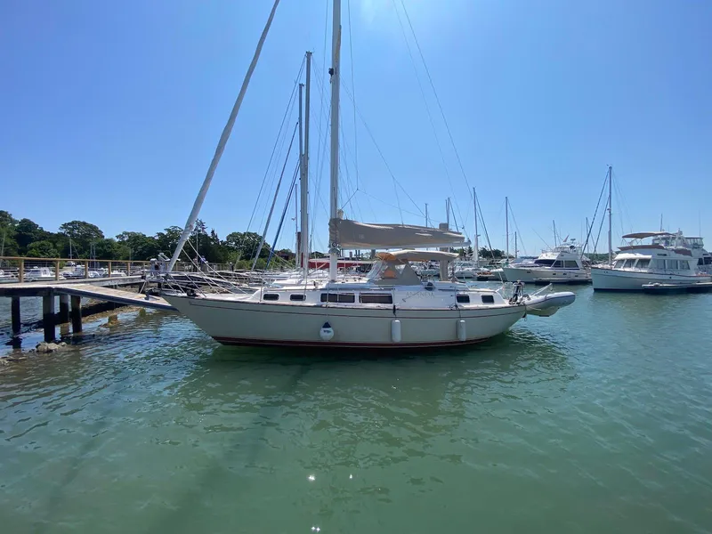 Slide: The Image of 1986 S2 11 Center Cockpit sailboat docked in a sunny marina. - 1
