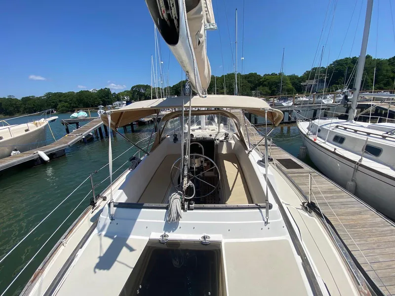 Slide: The Image of 1986 S2 11 Center Cockpit sailboat docked at marina under clear blue sky. - 11