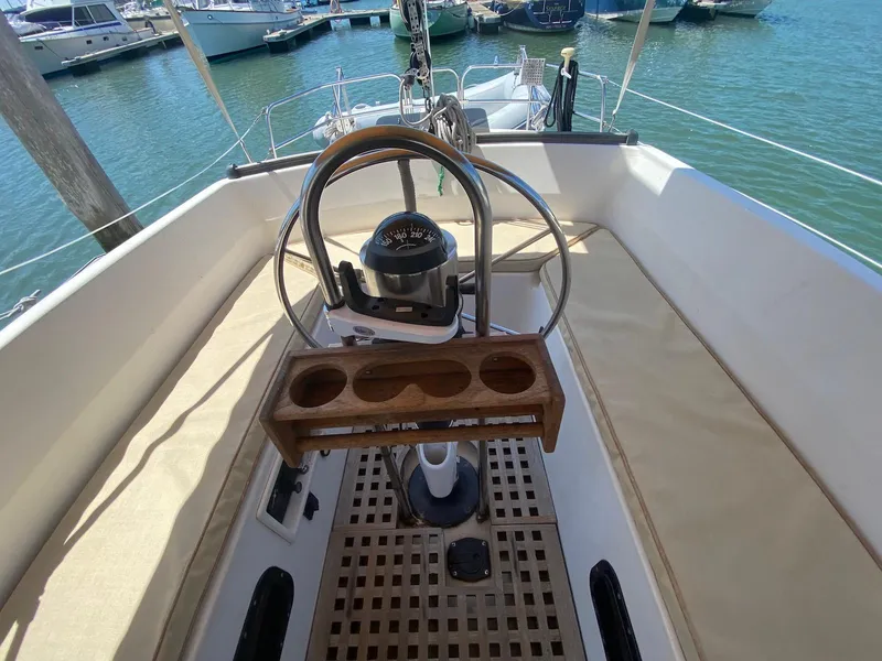 Slide: The Image of 1986 S2 11 Center Cockpit sailboat with steering wheel and compass, docked in marina. - 16