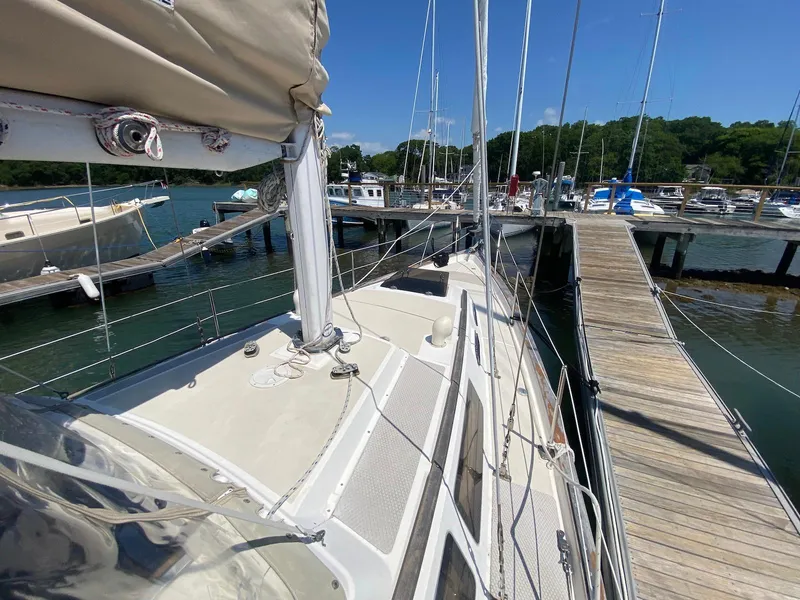 Slide: The Image of 1986 S2 11 Center Cockpit sailboat docked at a marina under clear blue skies. - 17