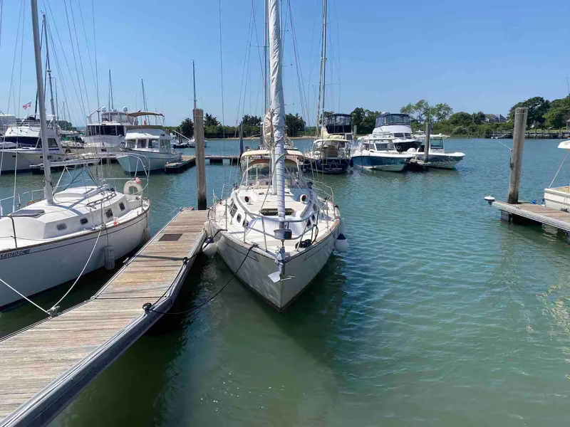 Slide: The Image of 1986 S2 11 Center Cockpit sailboat docked in a marina on a sunny day. - 2